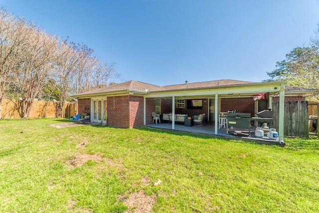 rear view of house with a yard, french doors, fence, and a patio