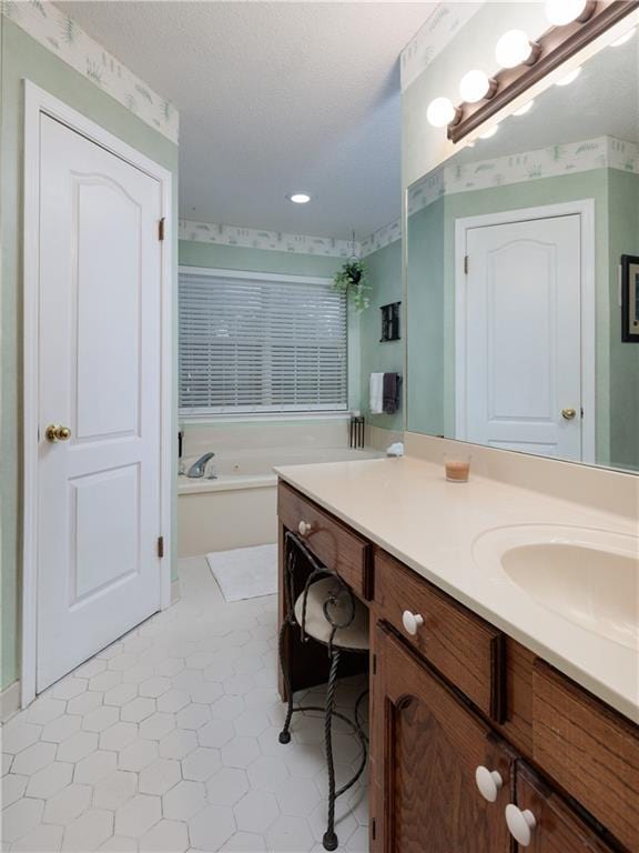 bathroom featuring tile patterned floors, a washtub, and vanity