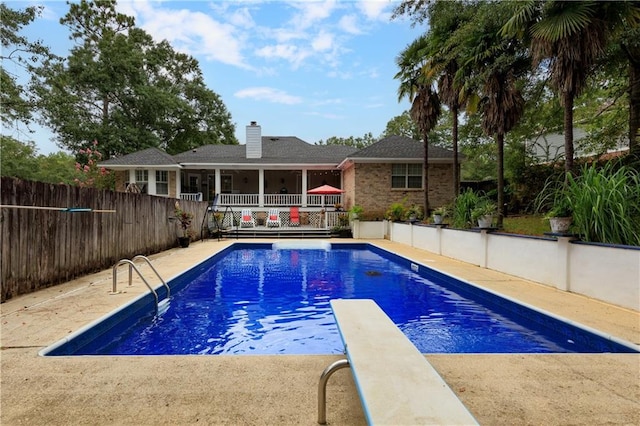 view of pool with a diving board and a wooden deck