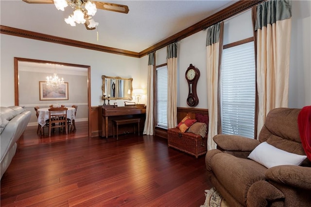 living area featuring ornamental molding, dark hardwood / wood-style floors, and ceiling fan with notable chandelier