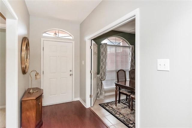 entryway with plenty of natural light and dark tile patterned floors