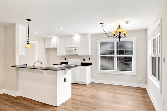 kitchen with hanging light fixtures, kitchen peninsula, a chandelier, white appliances, and white cabinets