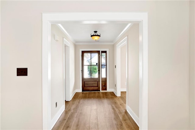 entryway featuring light wood-type flooring and crown molding