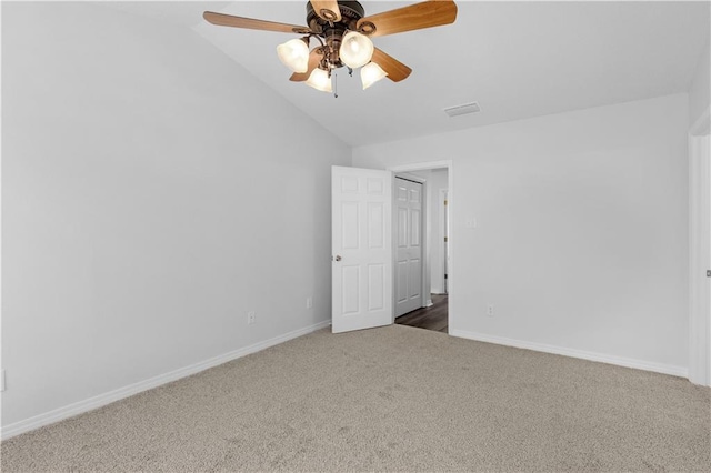 unfurnished bedroom with lofted ceiling, baseboards, visible vents, and carpet