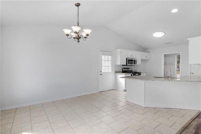 kitchen with lofted ceiling, a peninsula, a sink, white cabinets, and appliances with stainless steel finishes