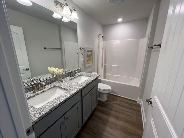 full bathroom featuring an inviting chandelier, toilet, shower / bath combination, wood-type flooring, and vanity