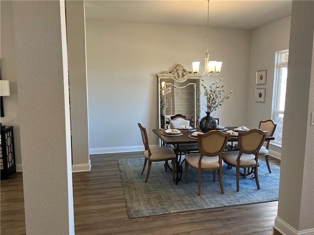 dining room with dark hardwood / wood-style floors and an inviting chandelier