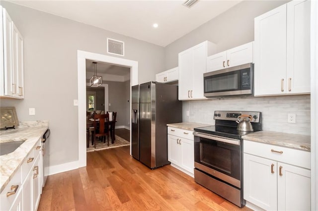 kitchen featuring white cabinets, light wood-style floors, visible vents, and stainless steel appliances