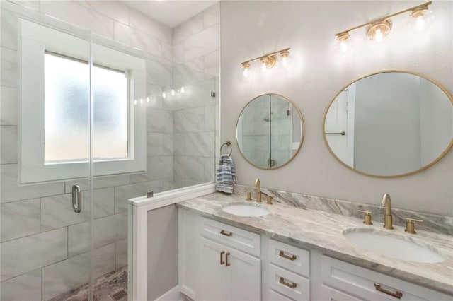 full bath with double vanity, a stall shower, and a sink