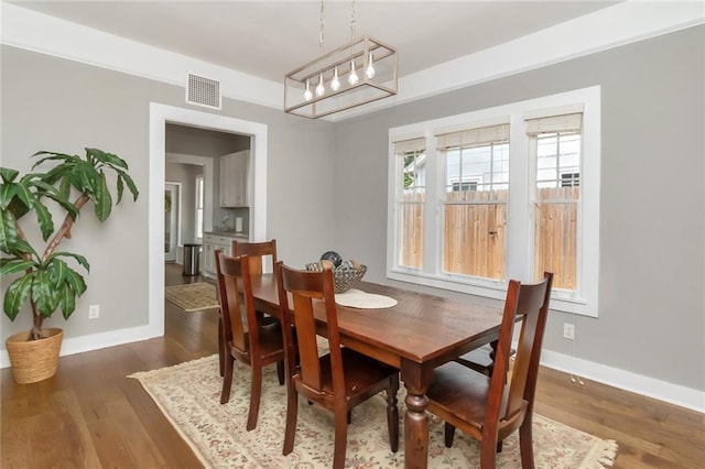 dining area with visible vents, baseboards, and wood finished floors