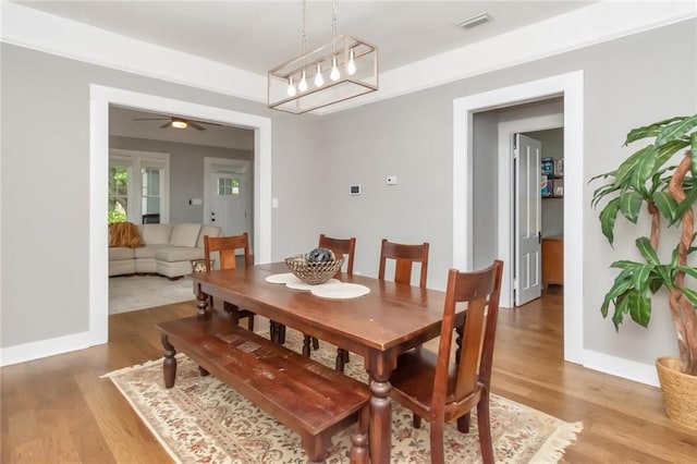 dining space with visible vents, light wood-type flooring, and baseboards