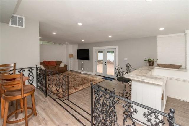 living room featuring recessed lighting, visible vents, light wood-style floors, and french doors