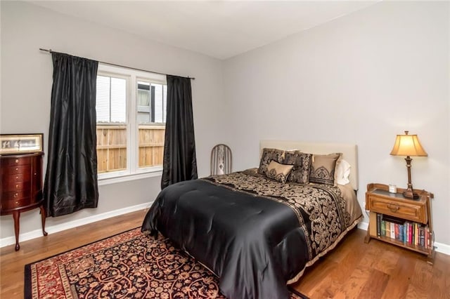 bedroom featuring wood finished floors and baseboards