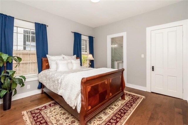 bedroom featuring ensuite bath, baseboards, and wood finished floors