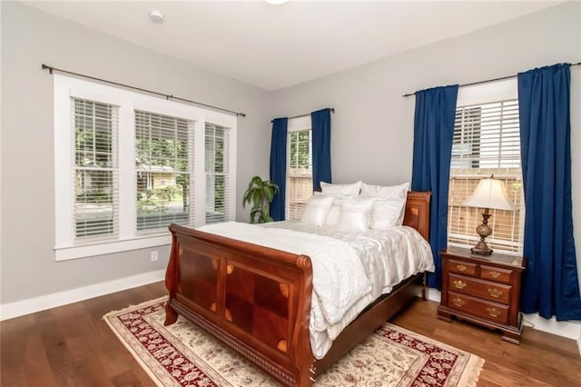 bedroom with baseboards and dark wood-style flooring