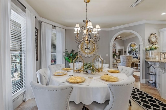 dining area with ornamental molding and a chandelier