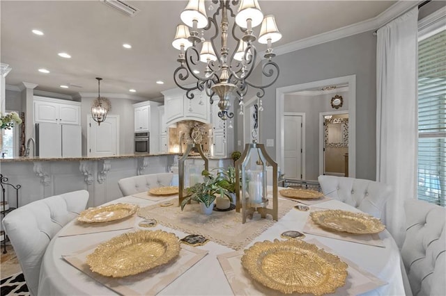 dining area with ornamental molding, sink, and a chandelier