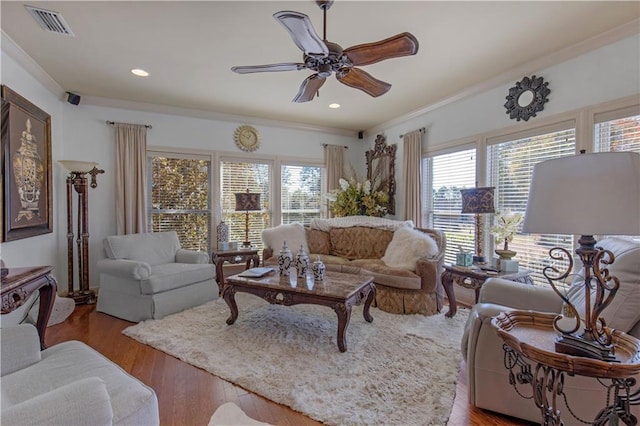 living room featuring ceiling fan, ornamental molding, and light hardwood / wood-style flooring