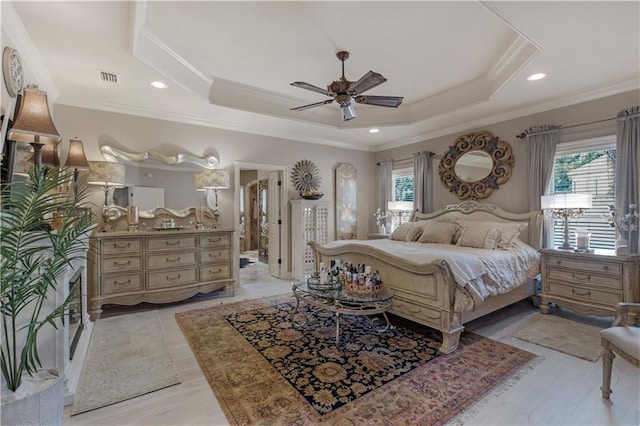 bedroom featuring multiple windows, crown molding, ceiling fan, and a tray ceiling