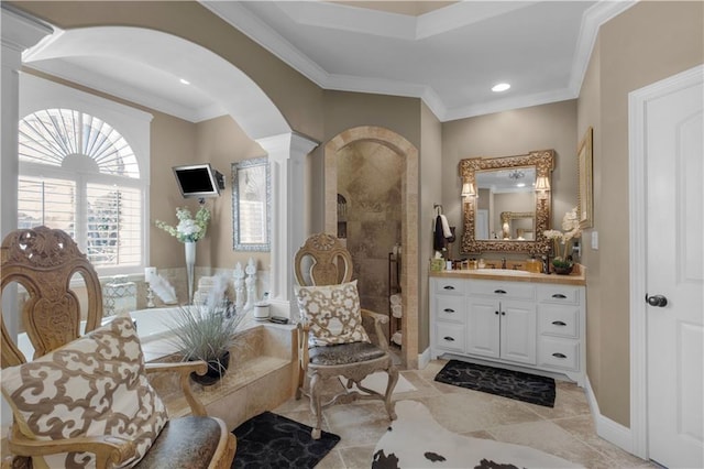 bathroom with ornamental molding, decorative columns, vanity, and a tile shower