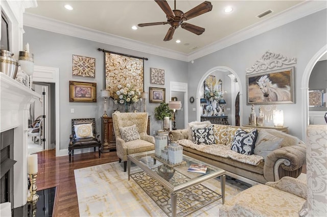 living room with hardwood / wood-style flooring, ornamental molding, and ceiling fan