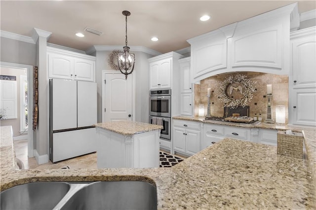 kitchen featuring stainless steel appliances, white cabinetry, and light stone countertops