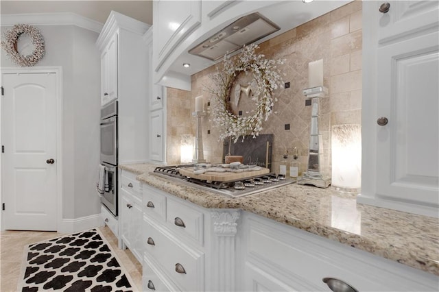 kitchen featuring stainless steel appliances, light stone countertops, and white cabinets