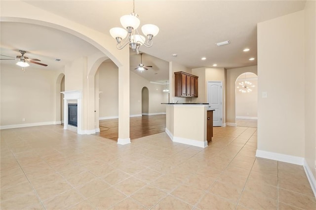 kitchen featuring ceiling fan with notable chandelier, kitchen peninsula, light tile patterned floors, and hanging light fixtures