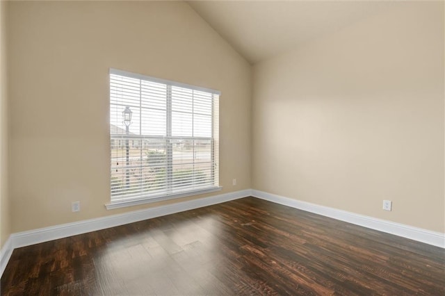 unfurnished room featuring lofted ceiling, dark hardwood / wood-style flooring, and a healthy amount of sunlight