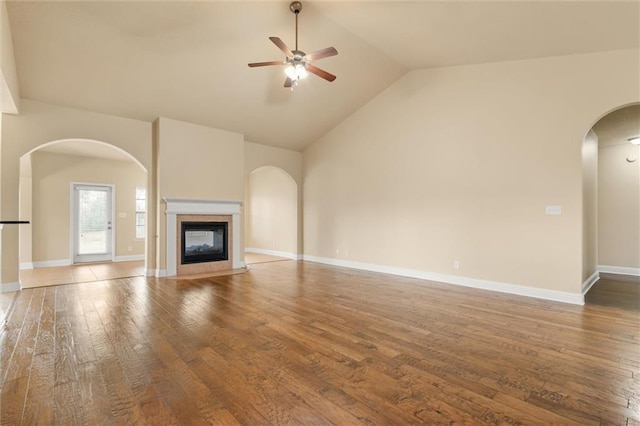 unfurnished living room with a high end fireplace, high vaulted ceiling, ceiling fan, and hardwood / wood-style flooring