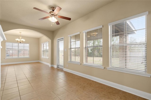 spare room featuring ceiling fan with notable chandelier and light tile patterned floors