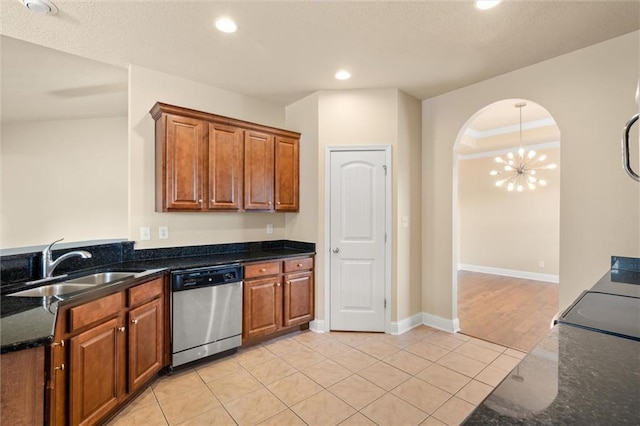 kitchen with sink, light tile patterned floors, dark stone countertops, and dishwasher