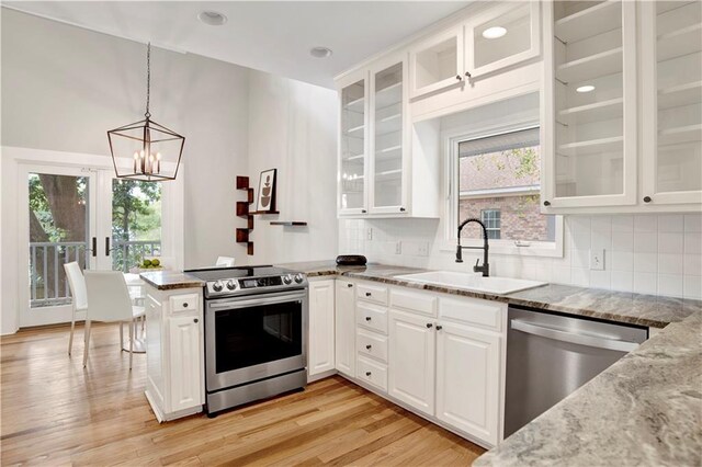 kitchen featuring a wealth of natural light, sink, stainless steel fridge with ice dispenser, and white cabinets