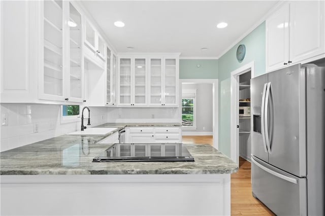 kitchen featuring white cabinetry, sink, a healthy amount of sunlight, and stainless steel fridge