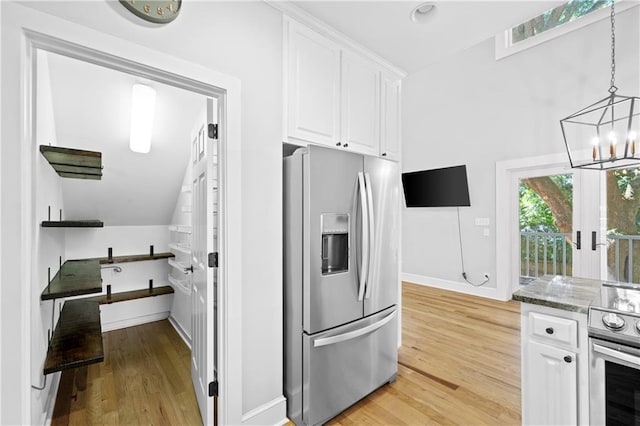 kitchen featuring appliances with stainless steel finishes, hanging light fixtures, light hardwood / wood-style floors, and white cabinetry