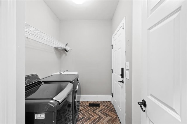 washroom featuring independent washer and dryer and dark parquet flooring