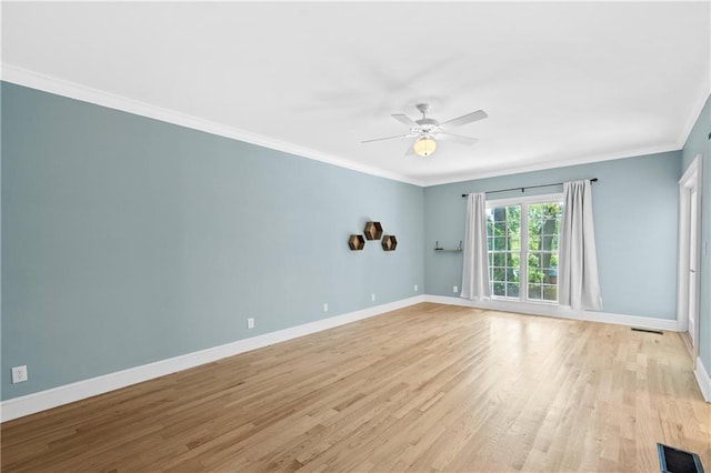 empty room featuring ornamental molding, light wood-type flooring, and ceiling fan