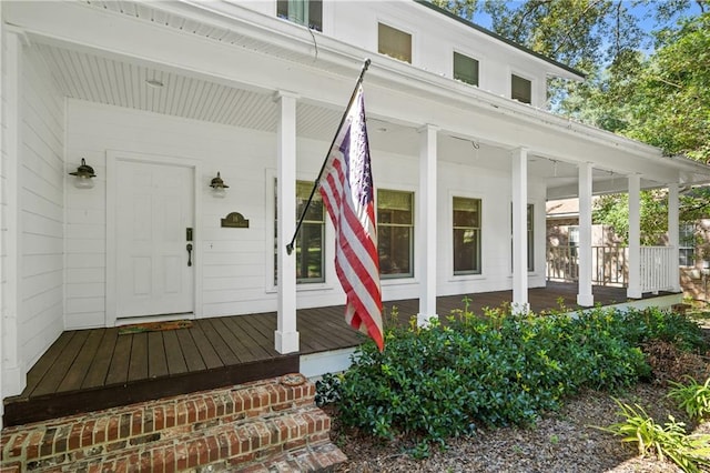 view of exterior entry featuring covered porch