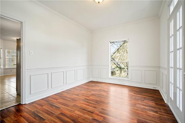 empty room with crown molding, a healthy amount of sunlight, and dark hardwood / wood-style floors