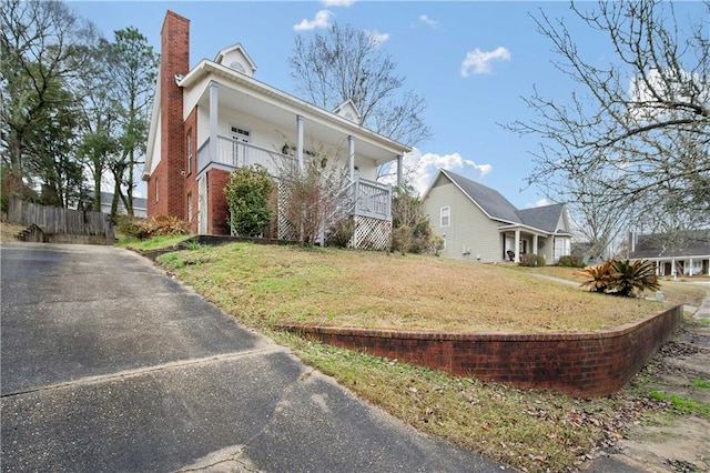 view of side of home with a yard and covered porch