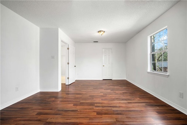 spare room with dark wood-type flooring and a textured ceiling