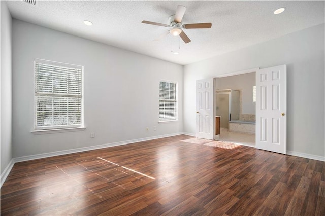 unfurnished room featuring a textured ceiling, dark wood-type flooring, and ceiling fan