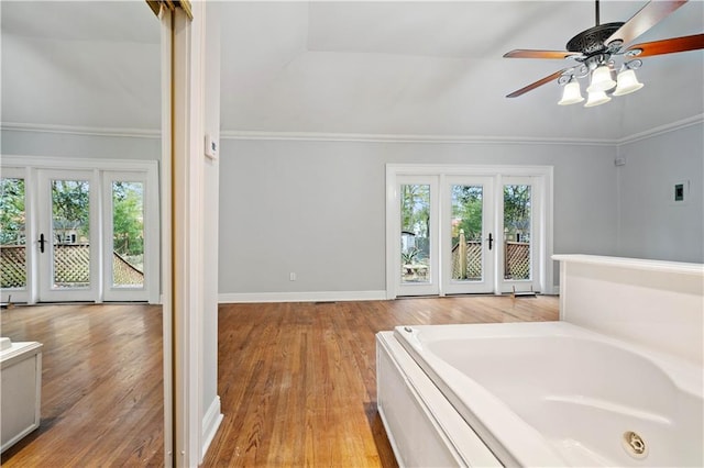 bathroom featuring crown molding, hardwood / wood-style floors, ceiling fan, and a bathtub