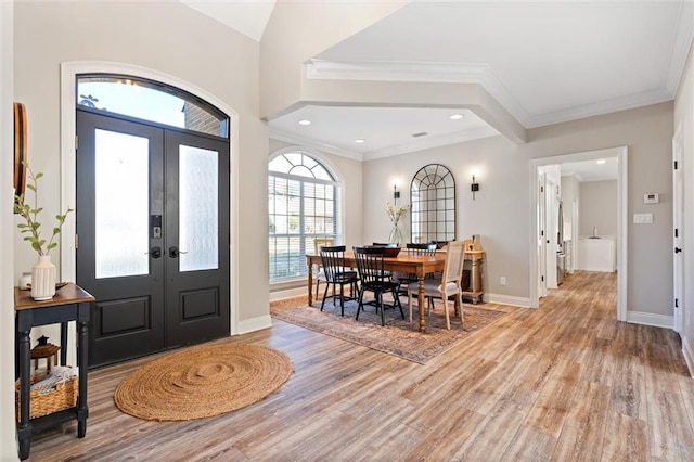 foyer entrance with french doors, light wood-type flooring, and ornamental molding