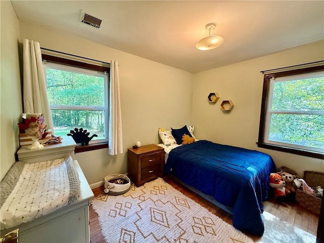 7020 Moffett Rd, Mobile, AL 36618 - bedroom with multiple windows, light wood-style flooring, and baseboards