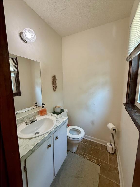 7020 Moffett Rd, Mobile, AL 36618 - bathroom with tile patterned flooring, toilet, vanity, a textured ceiling, and plenty of natural light