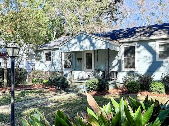 bungalow-style house with covered porch and a shingled roof