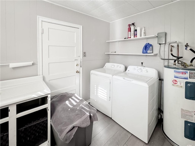 laundry area with electric water heater, laundry area, and washing machine and clothes dryer