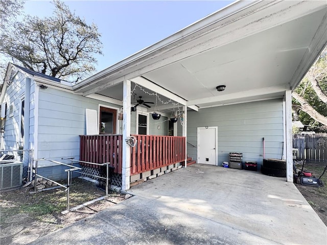 exterior space with an attached carport, fence, covered porch, ceiling fan, and central air condition unit