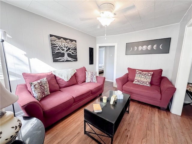 living area with wood finished floors and a ceiling fan